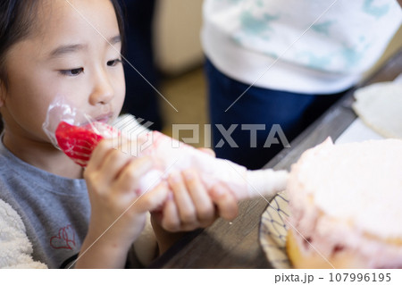 自宅でケーキを作る女の子 107996195