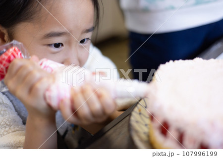 自宅でケーキを作る女の子 107996199