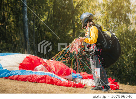 Paraglider on the ground. paragliders with full flight equipment look on soaring another paragliders at "Wat Pha Tak Suea" temple in nong khai thailand , Landscape from Beautiful View Mekong River. 107996640