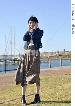 海岸のマリーナでポーズをとる若い女性 海岸のマリーナでポーズをとる若い女性 107997951