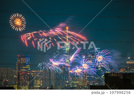 日本の東京都市景観 4年ぶり多摩川花火大会。川崎市制記念多摩川花火大会の会場側。奥に六本木ヒルズなど 107998256