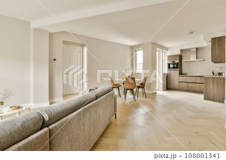a living room with wood flooring and white walls in an apartment, taken from the front view to the dining area 108001341