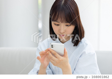 スマホを操作する若いビジネスウーマン スマホを操作する若いビジネスウーマン 108001862