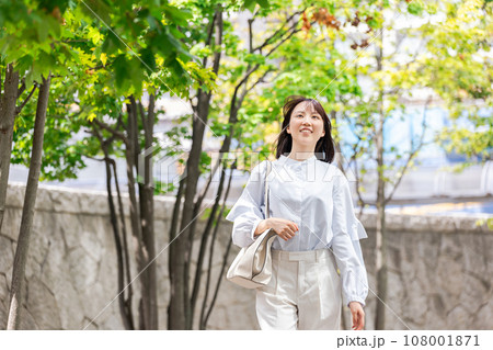 屋外を歩く笑顔のビジネスウーマン 屋外を歩く笑顔のビジネスウーマン 108001871