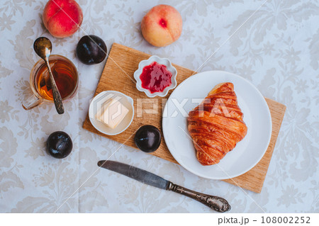 Croissant with tea, jam and fruits for breakfast Croissant with tea, jam and fruits for breakfast 108002252