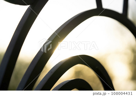 Curved forged modern fence on the balcony closeup. Curved forged modern fence on the balcony closeup. 108004431