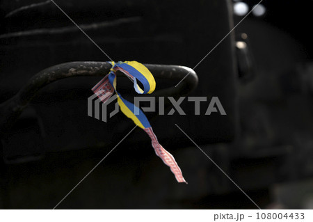 A ribbon with Ukrainian flag on the dark background. A ribbon with Ukrainian flag on the dark background. 108004433