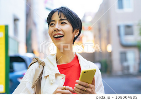 街でスマホを使う女性 108004885