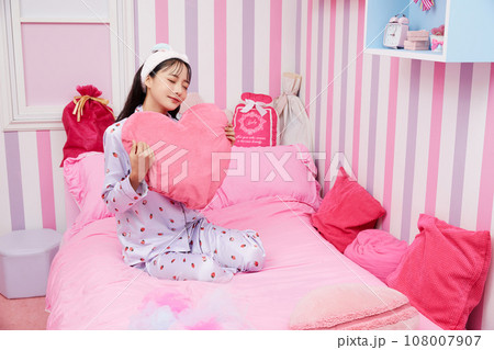 カラフルなベッドルームでリラックスする若い女性 108007907