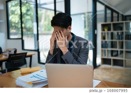 Portrait of business owner, man using computer and financial statements Anxious expression on expanding the market to increase the ability to invest in business Portrait of business owner, man using computer and financial statements Anxious expression on expanding the market to increase the ability to invest in business 108007995