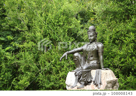 Female Goddess Chinese Buddha (Quan Yin) type ancient bronze statue sit in the big garden to be symbolic of the spiritual.  108008143