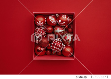 Red Christmas baubles decoration in the box on red background Red Christmas baubles decoration in the box on red background 108008871