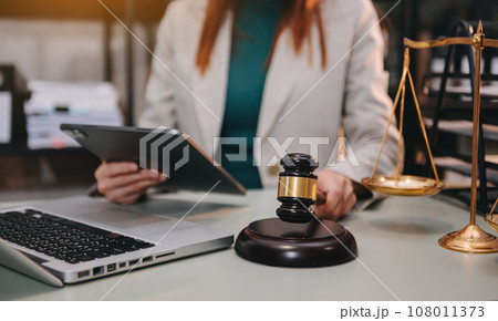 justice and law concept. asian woman lawyer working and judge in a courtroom the gavel, working with tablet and laptop and digital tablet computer justice and law concept. asian woman lawyer working and judge in a courtroom the gavel, working with tablet and laptop and digital tablet computer 108011373