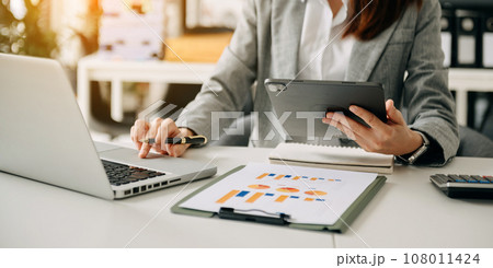 Businessman hand using smart phone laptop and tablet with social network diagram on desk as concept in morning light. 108011424