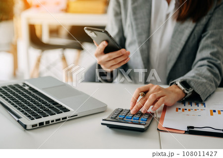 Businessman hand using smart phone laptop and tablet with social network diagram on desk as concept in morning light. 108011427