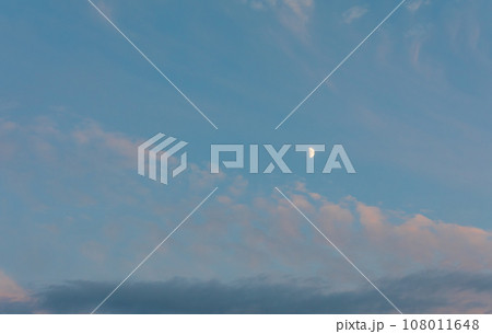 The moon floating in the sunset sky. 108011648