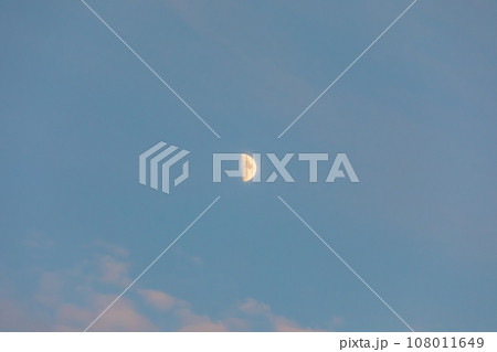 The moon floating in the sunset sky. 108011649