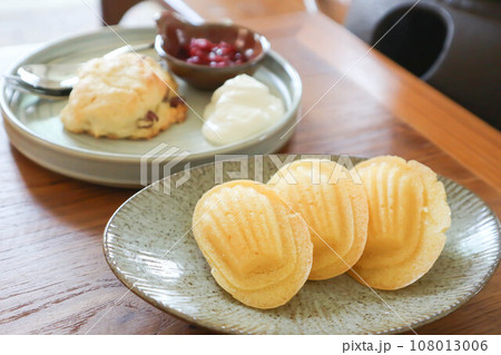 Madeleine or Madeleines and scone , cranberry scone or scone with whipped cream and berry sauce 108013006