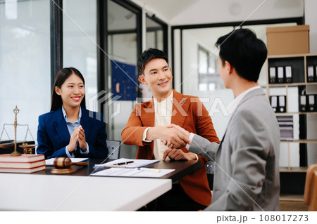 Man lawyer hand and women client shaking hand collaborate on working agreements with contract documents at the office.. 108017273
