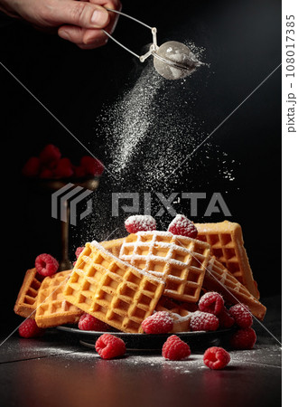 Belgian waffles with raspberries sprinkled with powdered sugar. Belgian waffles with raspberries sprinkled with powdered sugar. 108017385