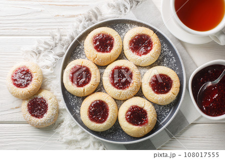 Hallongrottor Swedish Thumbprint Cookies closeup on the plate on the wooden table. Horizontal top view 108017555