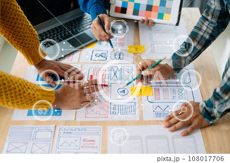 UX developer and ui designer brainstorming about mobile app interface wireframe design with customer breif and color code at office. with virtual icon. UX developer and ui designer brainstorming about mobile app interface wireframe design with customer breif and color code at office. with virtual icon. 108017706