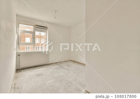 an empty room with white walls and no one person standing on the floor in front of the window looking out an empty room with white walls and no one person standing on the floor in front of the window looking out 108017800