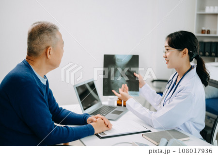 Serious Asia female doctor using clipboard is delivering great news talk discuss results or symptoms with female patient in clinic or hospital . 108017936