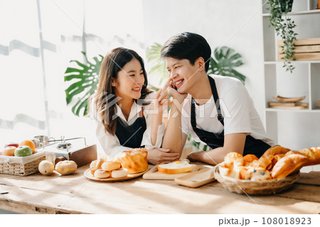 Image of newlywed couple cooking at home. Asia young couple cooking together with Bread and fruit in cozy kitchen 108018923