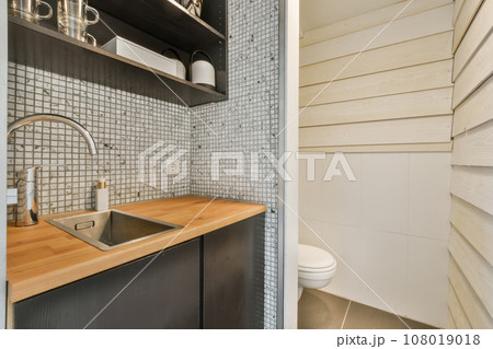 a kitchen with wood counter tops and white tiles on the wall behind it is a sink, fauced by an open shelf a kitchen with wood counter tops and white tiles on the wall behind it is a sink, fauced by an open shelf 108019018
