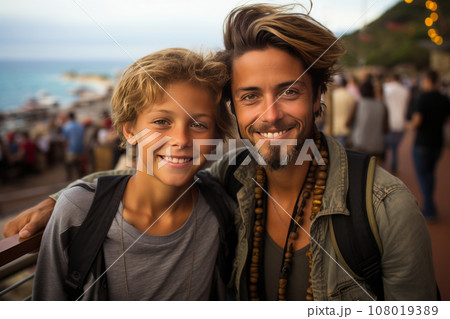 Young boy and his older brother against the backdrop of a city fair or amusement park on the seacoast. Cheerful, smiling brothers relaxing and enjoying their time. Leisure and entertainment. Young boy and his older brother against the backdrop of a city fair or amusement park on the seacoast. Cheerful, smiling brothers relaxing and enjoying their time. Leisure and entertainment. 108019389