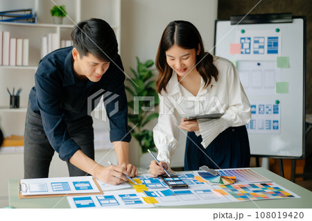 View of UI developer team brainstorming on their project with laptop, smartphone and digital tablet. Creative digital development agency.. View of UI developer team brainstorming on their project with laptop, smartphone and digital tablet. Creative digital development agency.. 108019420