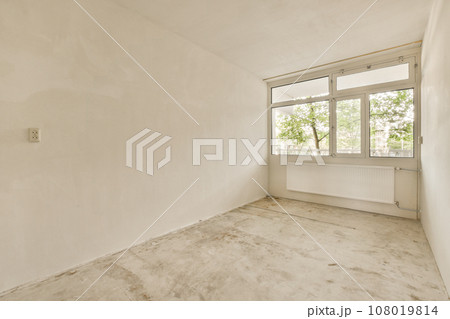 an empty room with white walls and no one person in the room looking out at the view through the window an empty room with white walls and no one person in the room looking out at the view through the window 108019814