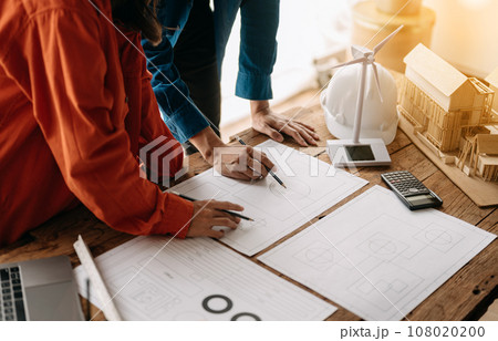 Creative architect projecting on the big drawings in the dark loft office 108020200