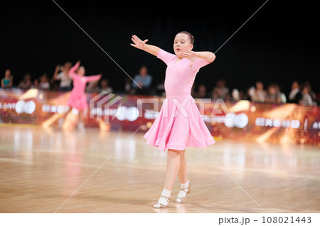 Dancer, a beautiful athlete in a pale pink dress against the background of the stage. Sports and ballroom dancing 108021443