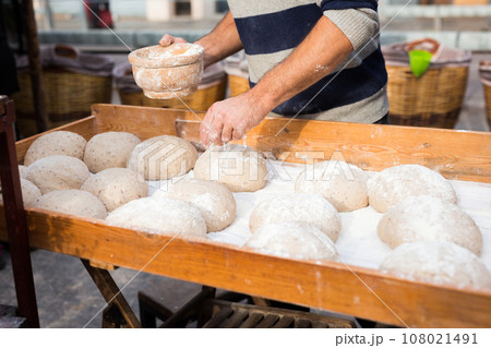Wheat dough shaped into loaves arranged in rows on the table before baking Wheat dough shaped into loaves arranged in rows on the table before baking 108021491
