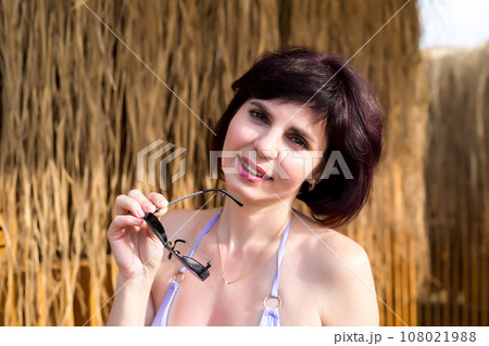 Beautiful brunette woman relaxing in Cabana beach house, personalized luxury vacation at resort 108021988