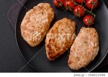 Delicious fresh chicken cutlets or meatballs with salt, spices and herbs 108022086