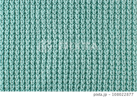 Texture of a rough knitted sweater close-up. Turquoise knitted backdrop for layout design Texture of a rough knitted sweater close-up. Turquoise knitted backdrop for layout design 108022877