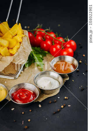 Set of different bowls of various dip sauces to french fries on dark background  108022901