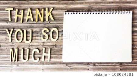 Thank you so much , text made of wooden letters on a wooden table, next to a notepad for writing. Thank you so much , text made of wooden letters on a wooden table, next to a notepad for writing. 108024381