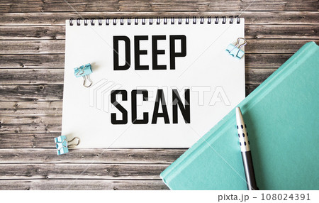 The text DEEP SCAN is written on a notebook, next to a diary, a pen and paper clips The text DEEP SCAN is written on a notebook, next to a diary, a pen and paper clips 108024391