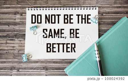 Notebook with text Don't be the same, be better in conceptual image on a wooden background 108024392