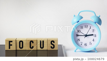 Wooden cubes lie on a black background. Cubes make up the word FOCUS. Business concept. 108024679