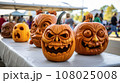 Pumpkin carving contest at a community event, showcasing creative designs. 108025008