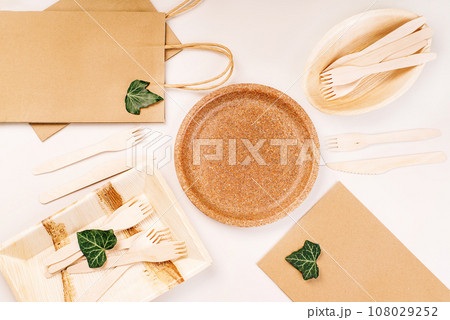 Recycling,eco-friendly concept.Disposable eco cutlery,plates,spoons,knives,forks on a light background.Craft paper bag for food delivery.Copy space.Eco craft paper tableware,cups,fast food containers. Recycling,eco-friendly concept.Disposable eco cutlery,plates,spoons,knives,forks on a light background.Craft paper bag for food delivery.Copy space.Eco craft paper tableware,cups,fast food containers. 108029252