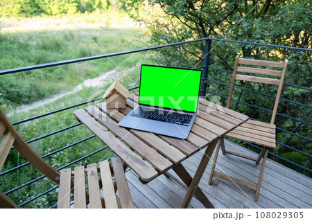 Mockup laptop screen template standing on patio table at the cottage. Mockup laptop screen template standing on patio table at the cottage. 108029305