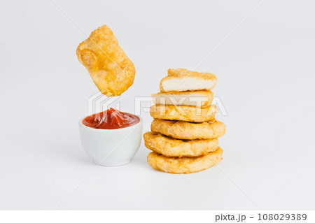 Levitation, breaded chicken nuggets, semi-finished product with fresh herbs on a white background. Fast food. Quick cooking at home. Copy space. 108029389