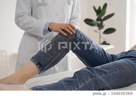 Doctor and patient are at the usual medical inspection in the clinic. Therapist examines a young woman's knee. Medicine concept 108030369