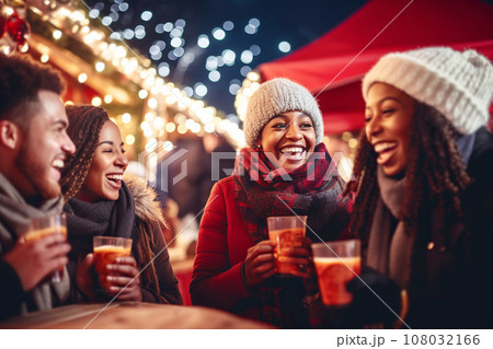 Multiracial friends drinking mulled wine at Christmas fair in festively decorated city Multiracial friends drinking mulled wine at Christmas fair in festively decorated city 108032166